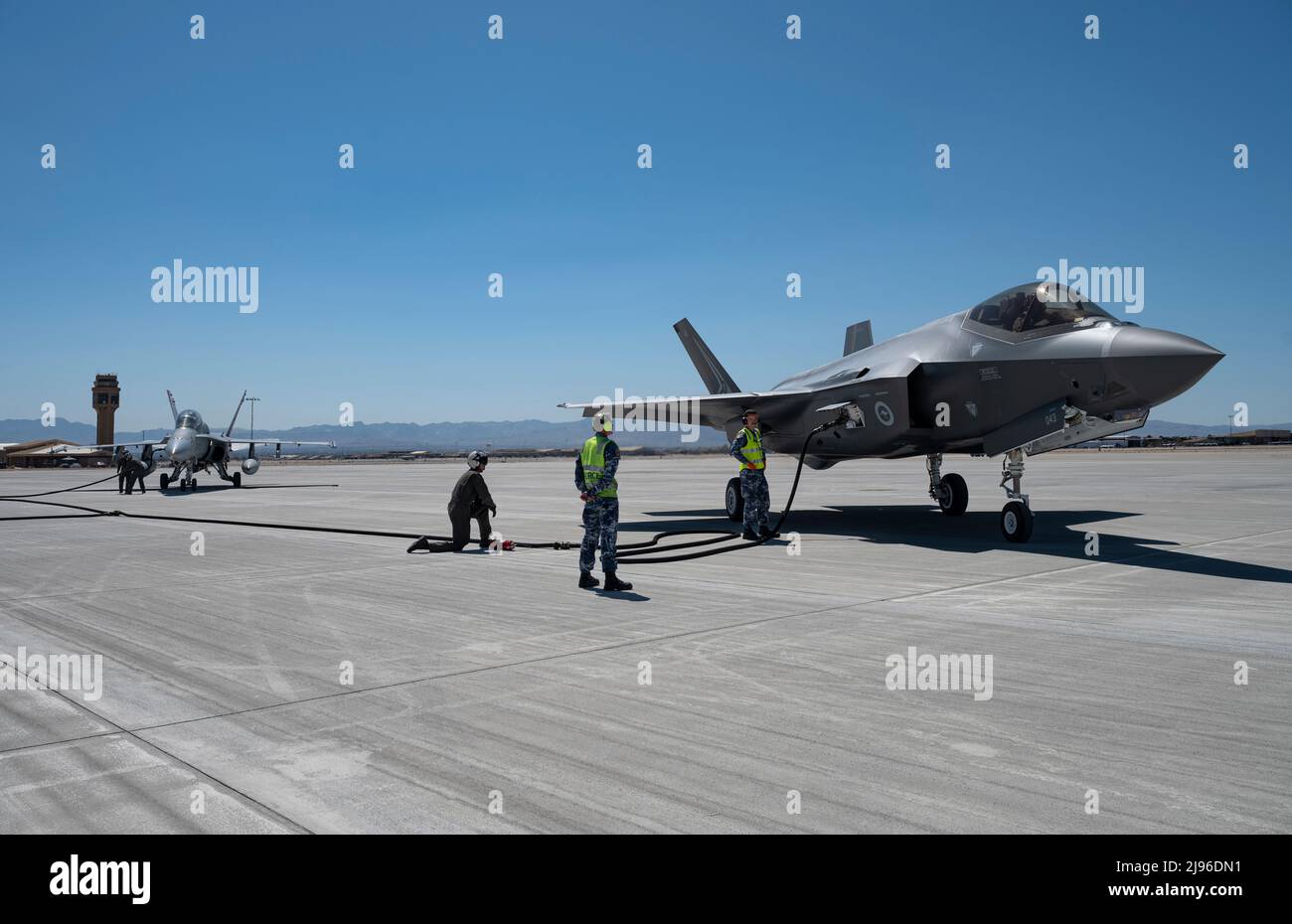 I membri della U.S. Marines e della Royal Australian Air Force (RAAF) lavorano insieme per rifornire un RAAF F-35A e un F-18C Hornet durante l'addestramento FARP (Forward Area Refiling Point) durante la Black Flag 22-1 alla Nellis AFB, 13 maggio 2022. La formazione FARP prepara le forze alleate e statunitensi a rifornire efficacemente gli aeromobili in luoghi austeri quando non è possibile il rifornimento aria-aria o quando le stazioni di rifornimento non sono accessibili. (STATI UNITI Air Force foto di William R. Lewis) Foto Stock
