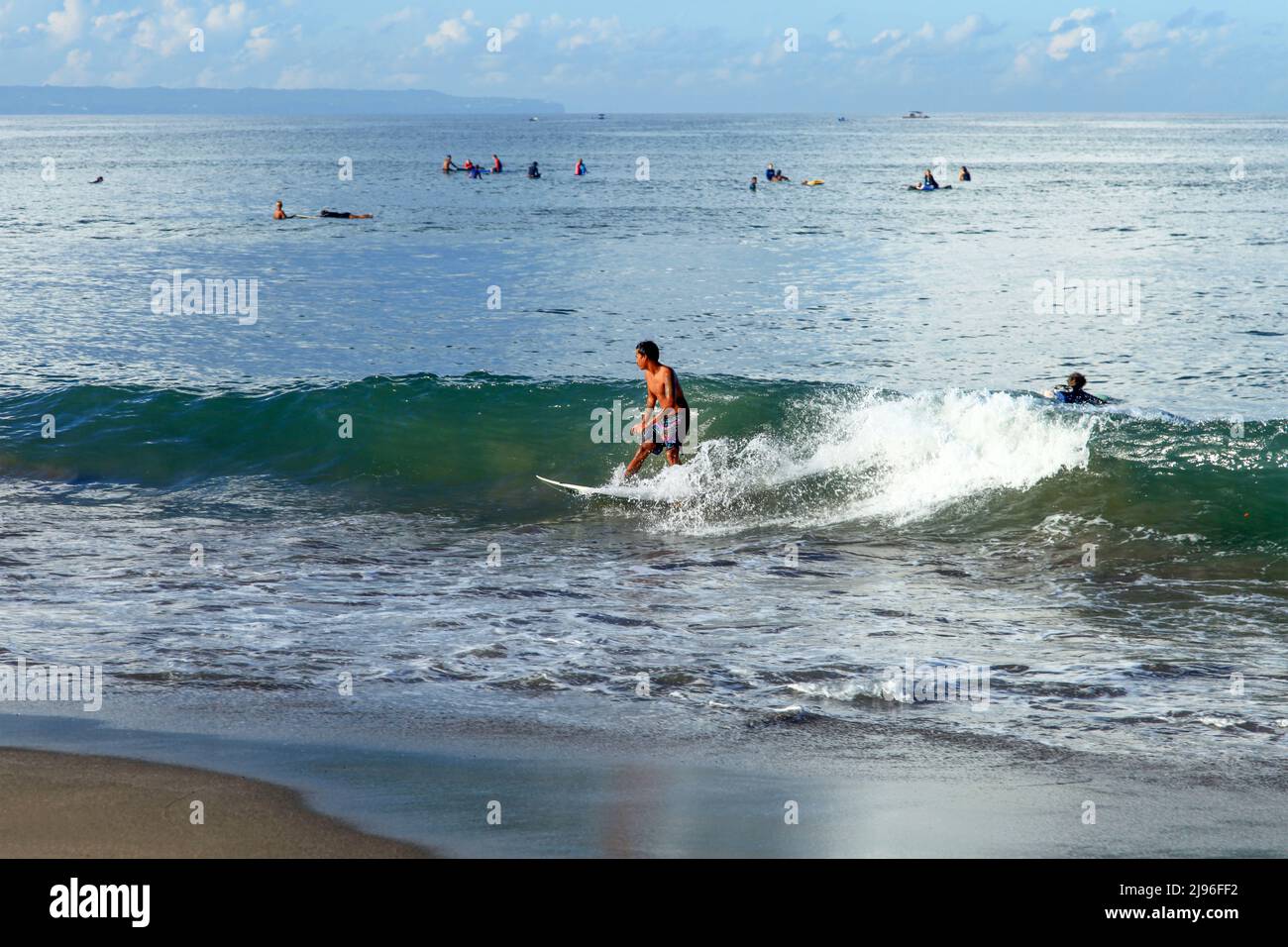 Un giovane surfista che cavalca un'onda a Batu Bolong Beach a Canggu, Bali, Indonesia Foto Stock