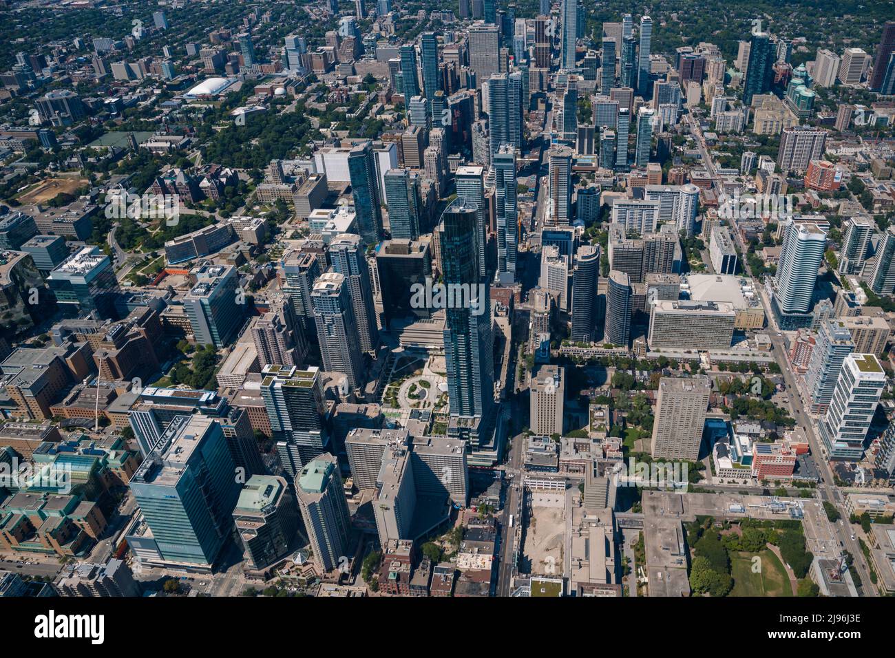 Vista aerea della città con crocevia e strade, case, edifici, parchi e parcheggi, ponti. Colpo di drone in elicottero. Ampio panoramico Foto Stock