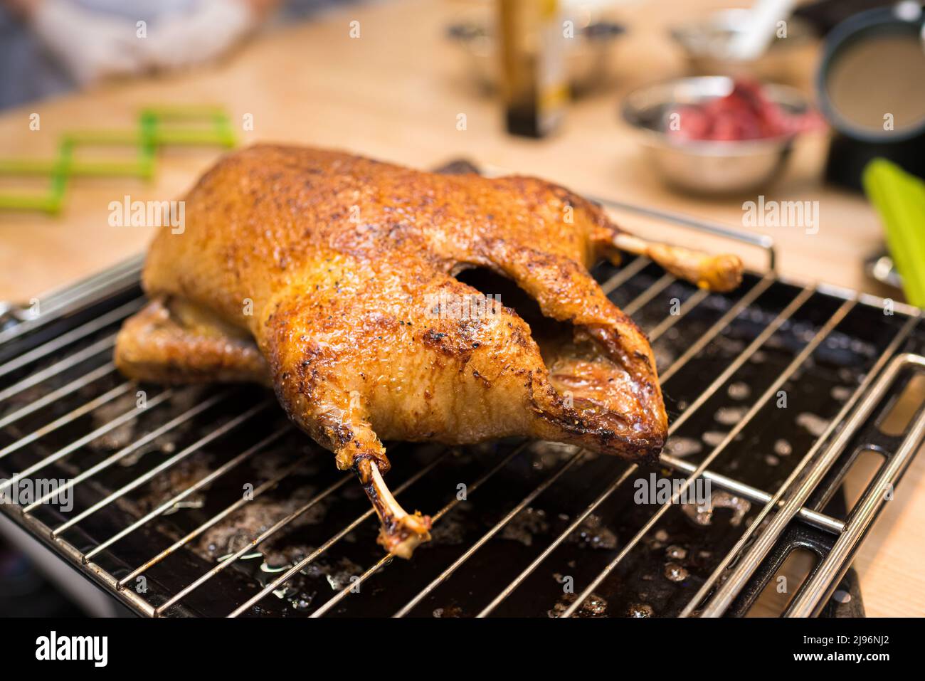 Anatra al forno su una rastrelliera e vassoio dal forno. L'anatra cotta si raffredda. Tostata su una pelle croccante. Foto Stock