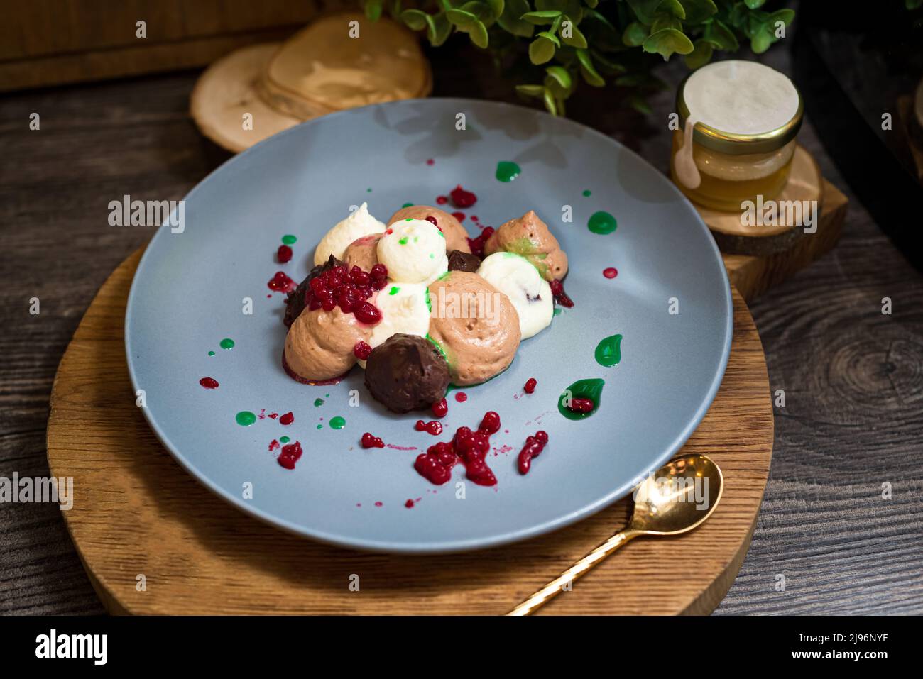 Tre mousse al cioccolato con caviale al lampone. Dessert su un piatto. Foto dark moody food. Foto Stock