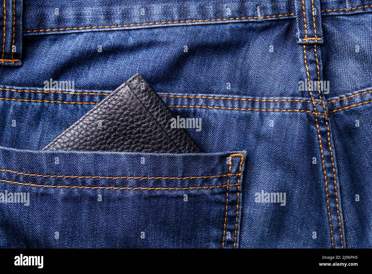 Portafoglio nero uomo nella tasca posteriore di vecchi jeans shabby. Foto Stock