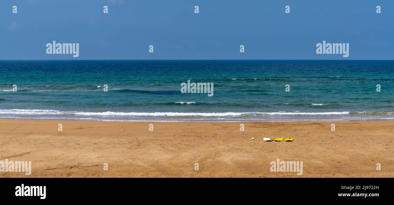 Bella e vuota spiaggia di sabbia dorata a Zarautz nel Paese Basco spagnolo con tre tavole da surf nella sabbia Foto Stock