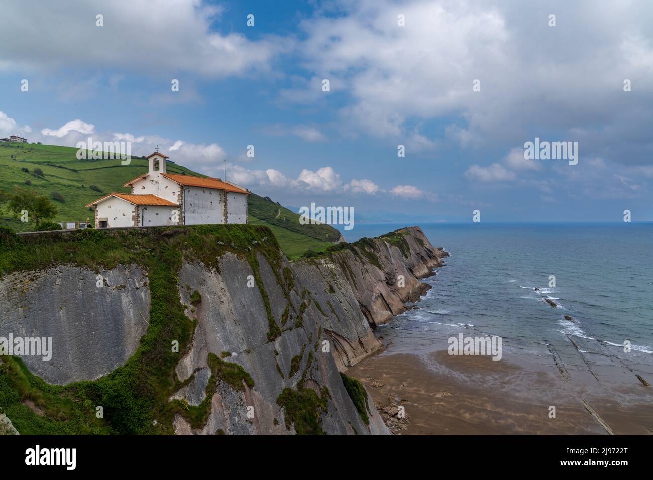 Vista della cappella dell'Hermitage di San Telmo e delle formazioni rocciose di Flysch sulla costa dei Paesi Baschi a Zumaia Foto Stock
