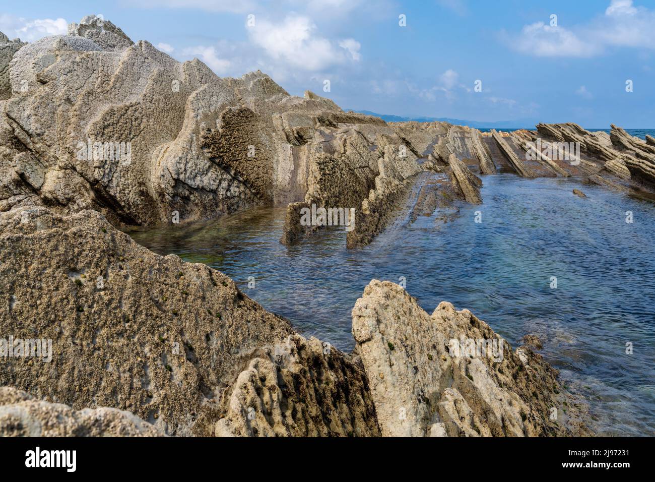 Una vista delle formazioni rocciose di Flysch e delle piscine di marea sulla costa dei Paesi Baschi vicino a Zumaia Foto Stock