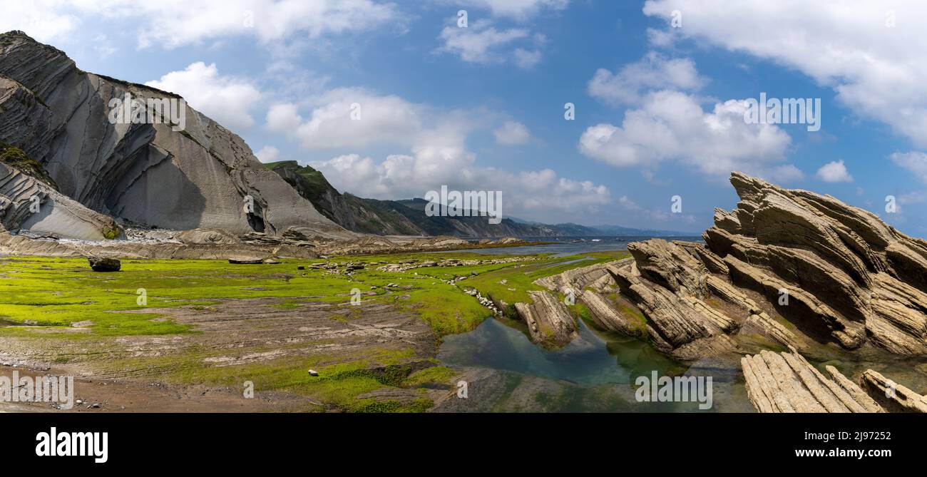 Una vista panoramica delle formazioni rocciose di Flysch e delle scogliere con piscine di marea sulla costa dei Paesi Baschi vicino a Zumaia Foto Stock