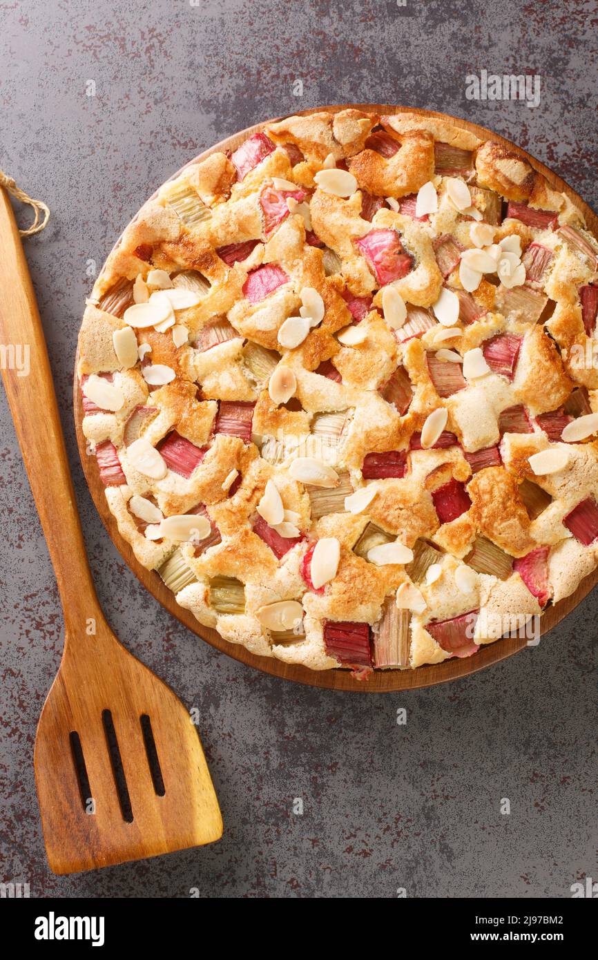 Torta svedese di rabarbaro Rabarberkaka con scaglie di mandorle primo piano nel piatto sul tavolo. Vista dall'alto verticale Foto Stock