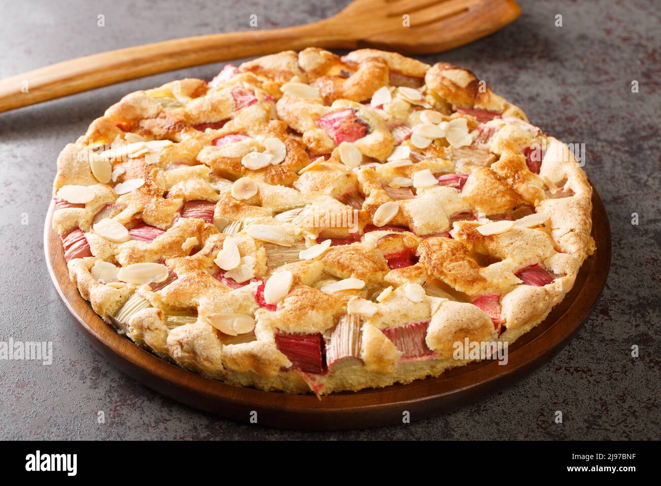Torta scandinava Rhubarb con scaglie di mandorle primo piano nel piatto sul tavolo. Orizzontale Foto Stock