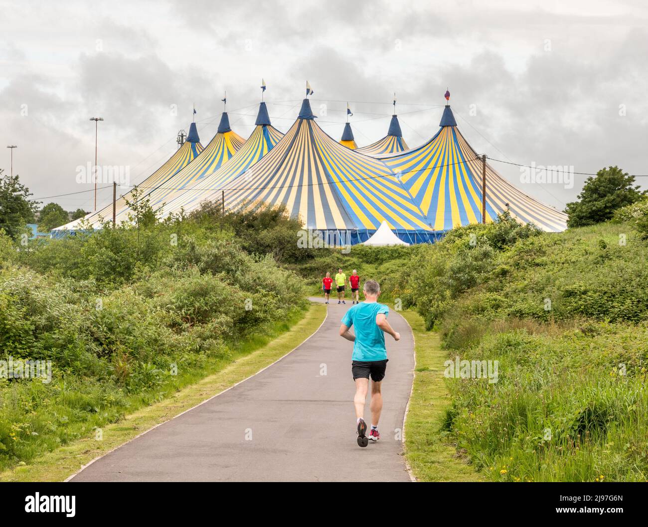 The Marina, Cork, Irlanda. 21st maggio 2022. Jogger e camminatori fuori per l'esercitazione di mattina presto sulla Marina contro uno sfondo della tenda grande che è stata eretta per la serie di concerto dal vivo al Marquee. La serie di concerti inizia il 27th maggio con le Coronas e si terrà fino alla fine di giugno. - Credit; David Creedon / Alamy Live News Foto Stock