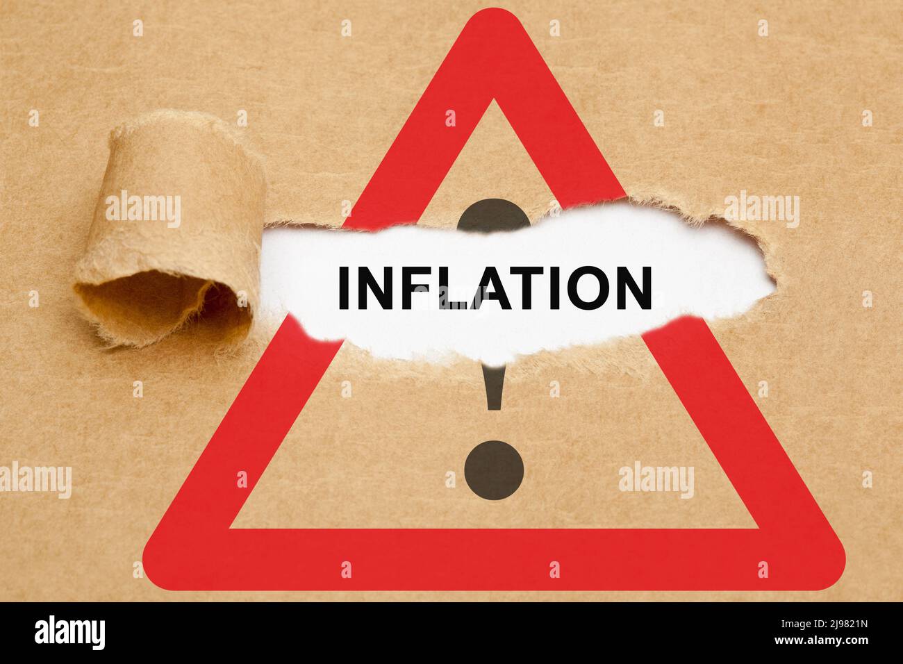 Parola inflazione che appare dietro carta bruno strappato sul segno di attenzione strada. Concetto di aumento del tasso di inflazione e di avvicinamento alla crisi finanziaria. Foto Stock