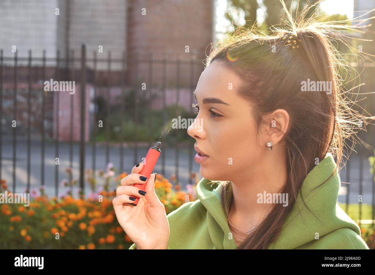 Bella bruna fumo di sigaretta elettronica in luoghi pubblici Foto Stock