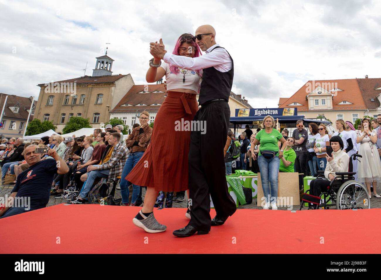 Ostritz, Germania. 21st maggio 2022. Una donna e un uomo ballano sulla passerella per la sfilata di moda, che porta il tema della democrazia, del cosmopolitismo e della tolleranza. Il Festival della Pace è stato parte integrante della comunità per anni per contrastare gli eventi orientati alla destra nella città. Credit: Daniel Schäfer/dpa/Alamy Live News Foto Stock