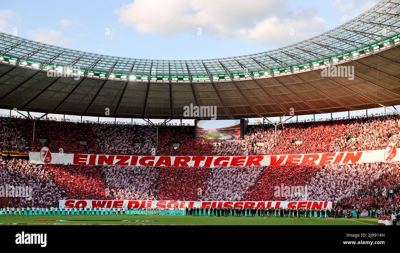 Berlino, Germania. 21st maggio 2022. Calcio: Coppa DFB, SC Friburgo - RB Leipzig, finale, Olympiastadion. I tifosi di Friburgo festeggiano la loro squadra negli stand prima della partita con un banner che legge "Club unico, il calcio dovrebbe essere come te!" (NOTA IMPORTANTE: In conformità con i requisiti della DFL Deutsche Fußball Liga e/o della DFB Deutscher Fußball-Bund, è vietato sfruttare o sfruttare le fotografie scattate nello stadio e/o della partita sotto forma di immagini di sequenza e/o di serie fotografiche video-simili). Credit: Jan Woitas/dpa/Alamy Live News Foto Stock