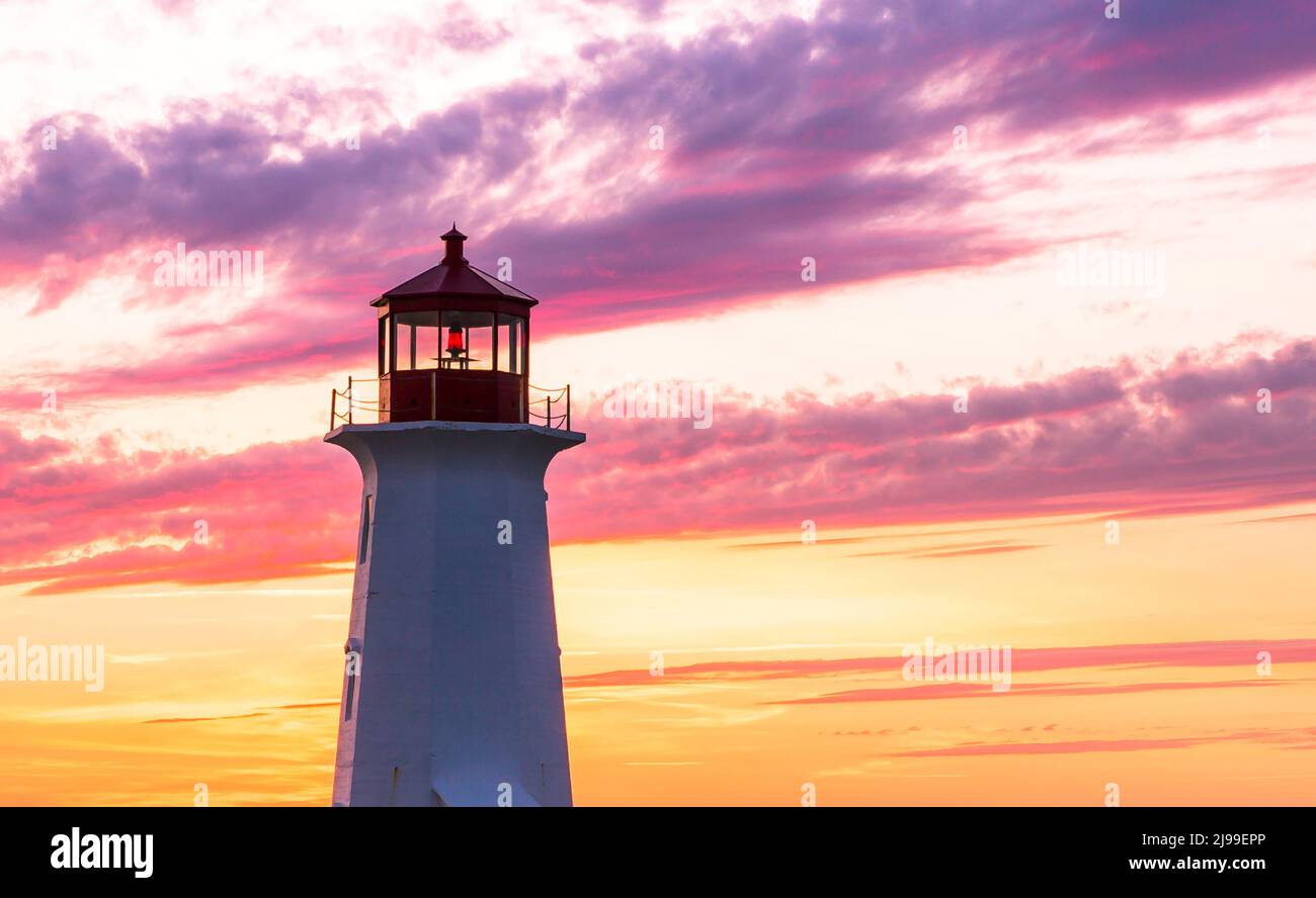 Faro di Peggy's Cove durante un tramonto vivace. Costa atlantica, Nuova Scozia, Canada. La località turistica più visitata in Canada Atlantico Foto Stock