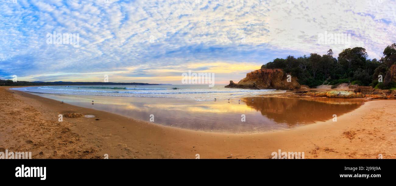 Luce dorata di sole che sorge sulle sabbie pulite della spiaggia di Tathra della costa Sapphire in Australia. Foto Stock