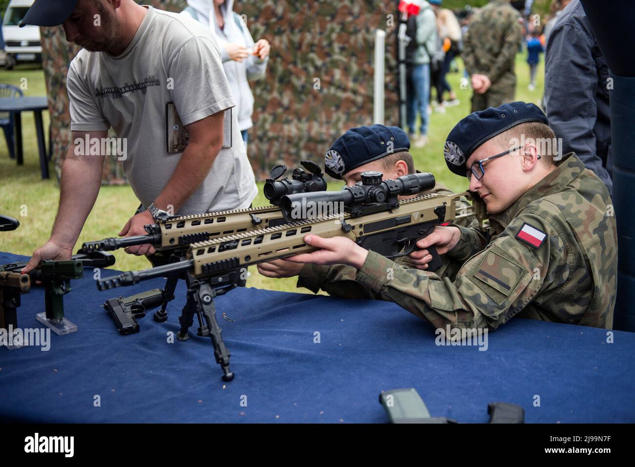 Bambini e adulti provano fucili e pistole al picnic militare. Il reclutamento per il nuovo servizio militare generale volontario della Polonia inizia dal maggio 21st quando il governo cerca di raddoppiare le dimensioni delle sue forze armate. Il ministero della Difesa ha rivelato i dettagli sulle condizioni per il servizio di tutto l'anno, compresi i tassi di retribuzione e benefit.The introduzione del servizio militare di base volontario è stato previsto dalla legge sulla difesa della Patria, Che è stato inizialmente proposto dal governo in ottobre, ma firmato in legge poco dopo l'invasione russa dell'Ucraina. Foto Stock