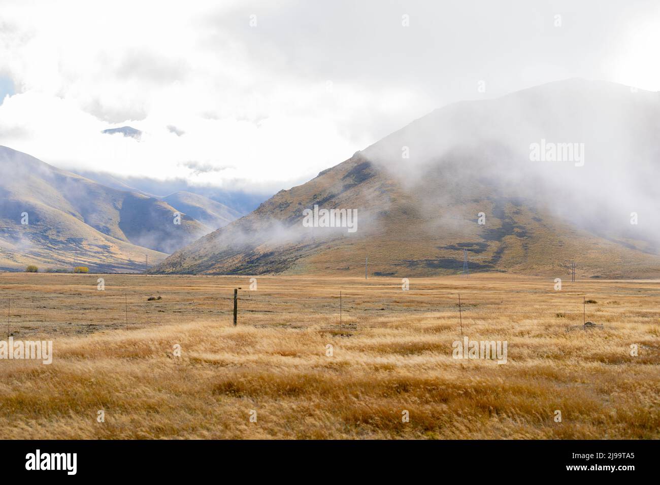 Bassa nube su Burkes rurale e alpino Passo paesaggio di Mackenzie Paese in Canterbury Sud, Nuova Zelanda. Foto Stock