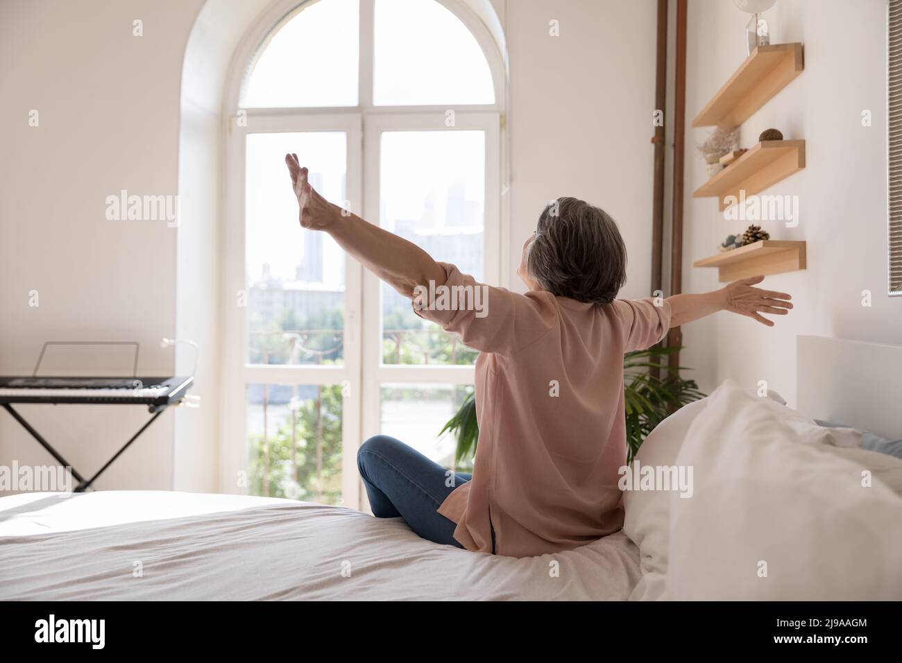 Spensierate la signora anziana sentendosi piena di energia dopo il sonno abbastanza Foto Stock