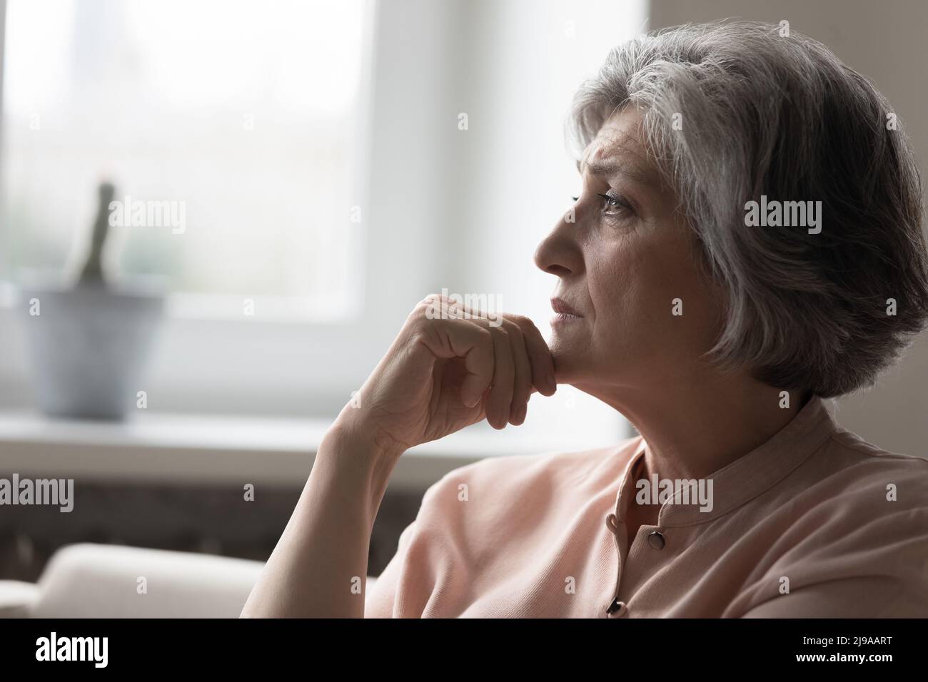 Frustrata maturo grigio capelli 50s donna pensiero su cattive notizie Foto Stock