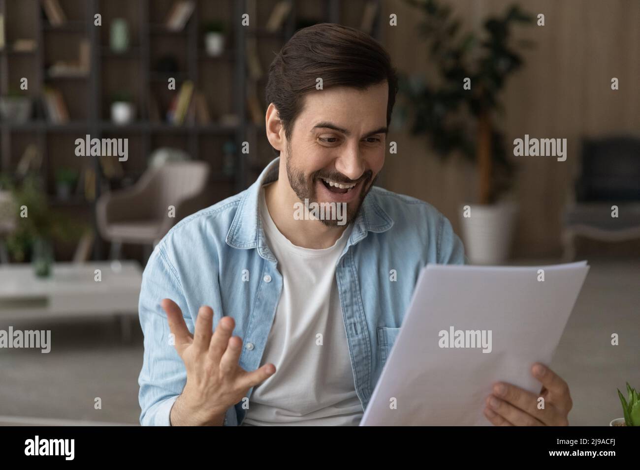 Freelance maschile di successo millennial ottenere carta documento grande offerta di lavoro Foto Stock