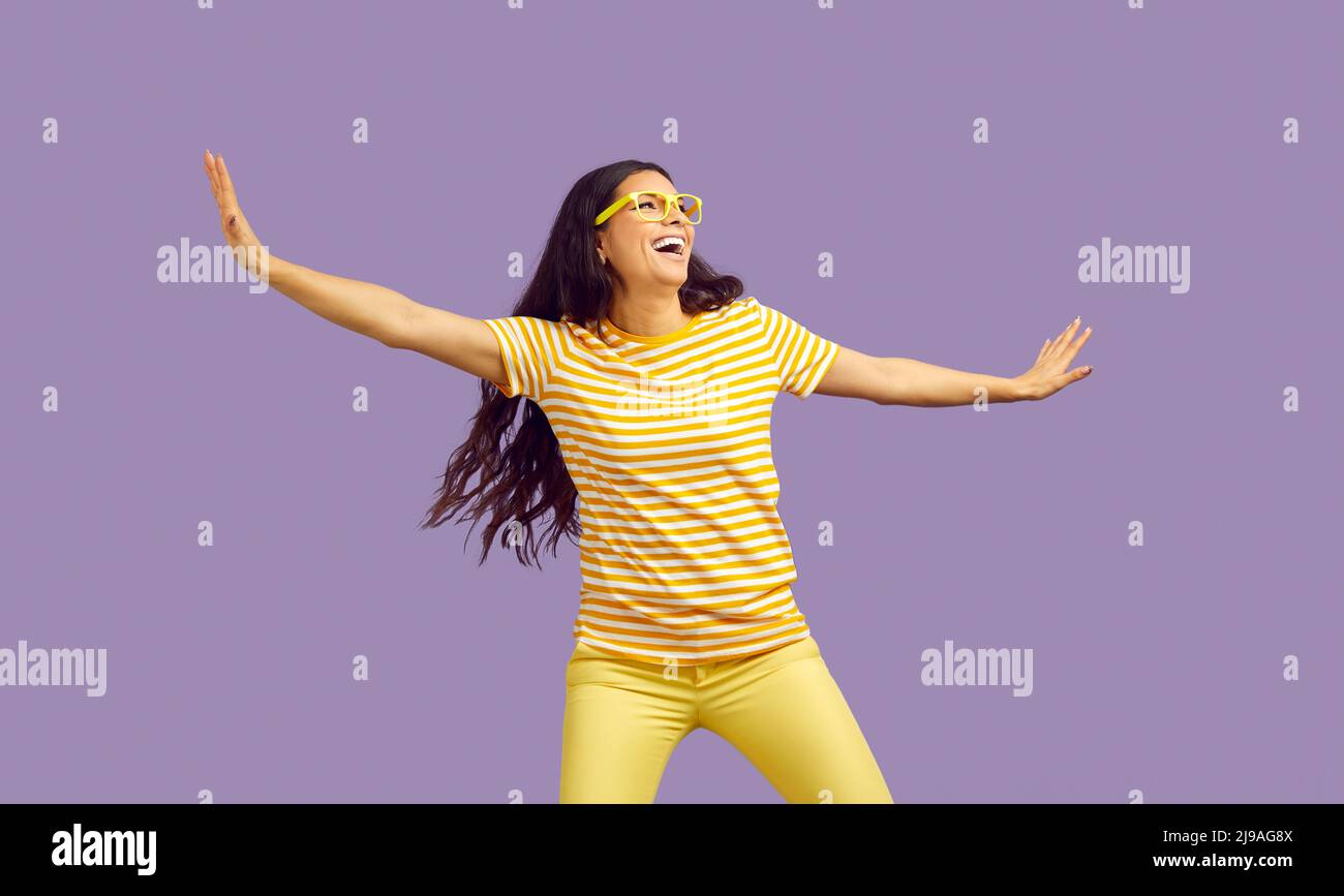 Felice giovane donna divertente gioire e divertirsi isolato su sfondo viola pastello. Foto Stock