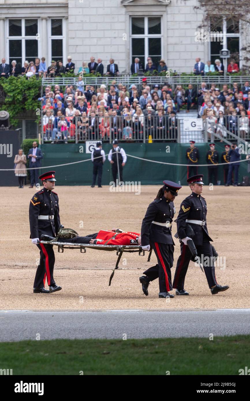 Un membro delle Guardie irlandesi svenisce oggi sotto l’alta temperatura durante la revisione del generale maggiore di Trooping the Color alla Horse Guards Parade Foto Stock