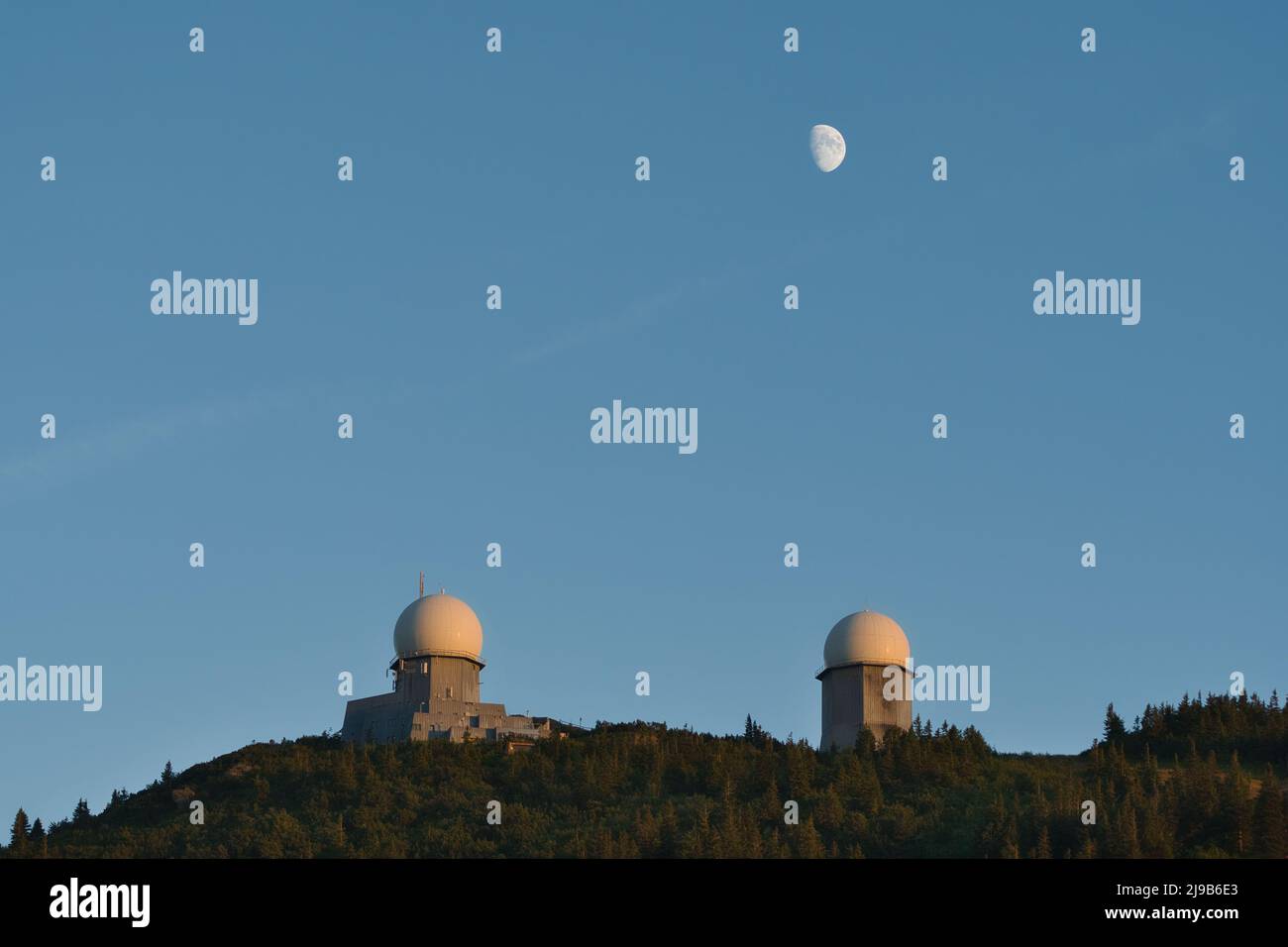 Le due torri sul monte Großer Arber all'ora blu con la luna sopra. Parte di Lamer Winkel, Foresta Bavarese, Palatinato superiore, Baviera, Germania. Foto Stock