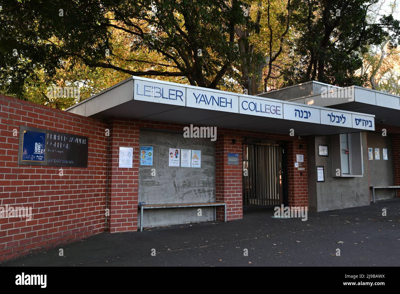 Ingresso principale al college Leibler Yavneh della scuola ebraica di Melbourne, con insegne blu di rilievo in inglese ed ebraico sopra il cancello Foto Stock