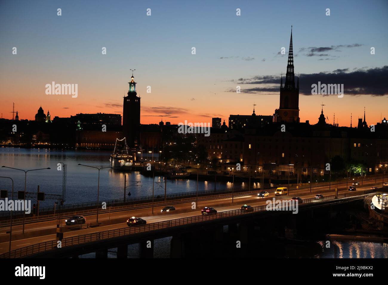 Vista sulla città di Stoccolma, capitale della Svezia, vista sull'acqua da Slussen durante l'ora d'oro. Colori e nuvole nel cielo Foto Stock