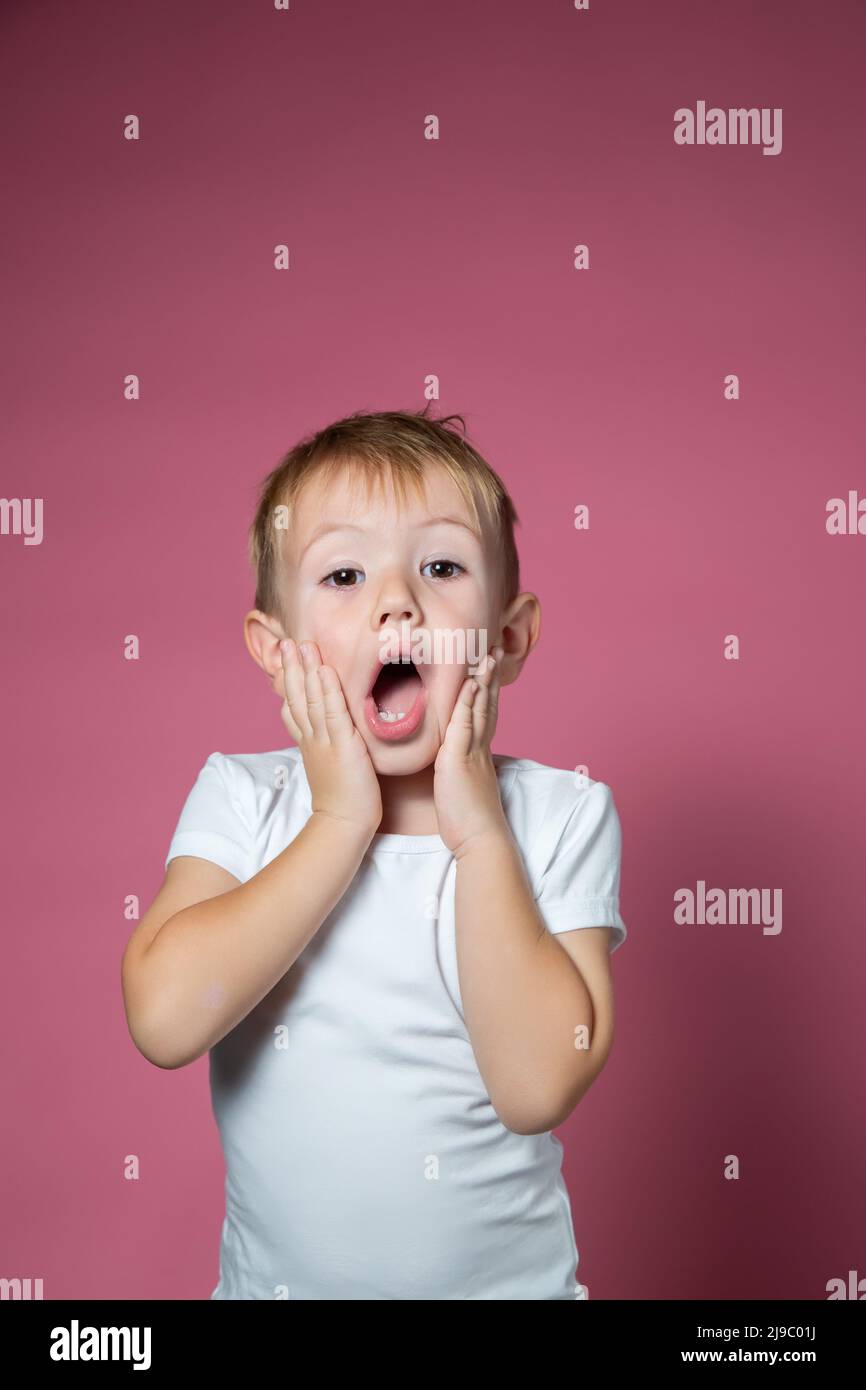 Il ragazzo caucasico di 3 anni fa volti spaventosi mentre guarda la fotocamera Foto Stock