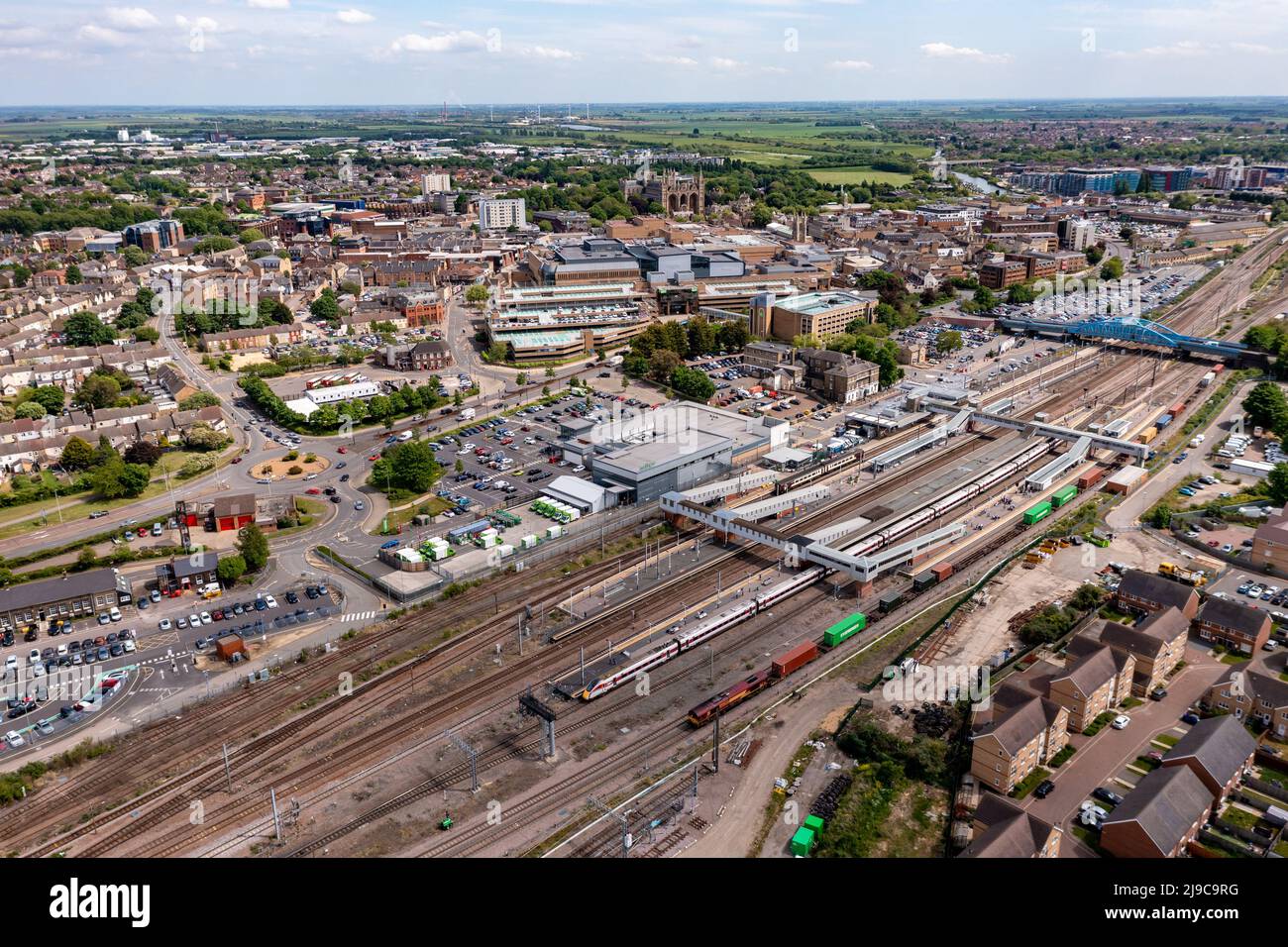 Una vista panoramica aerea dei treni passeggeri e merci in attesa sulle piattaforme della stazione ferroviaria di Peterborough sulla linea ferroviaria principale della costa orientale Foto Stock