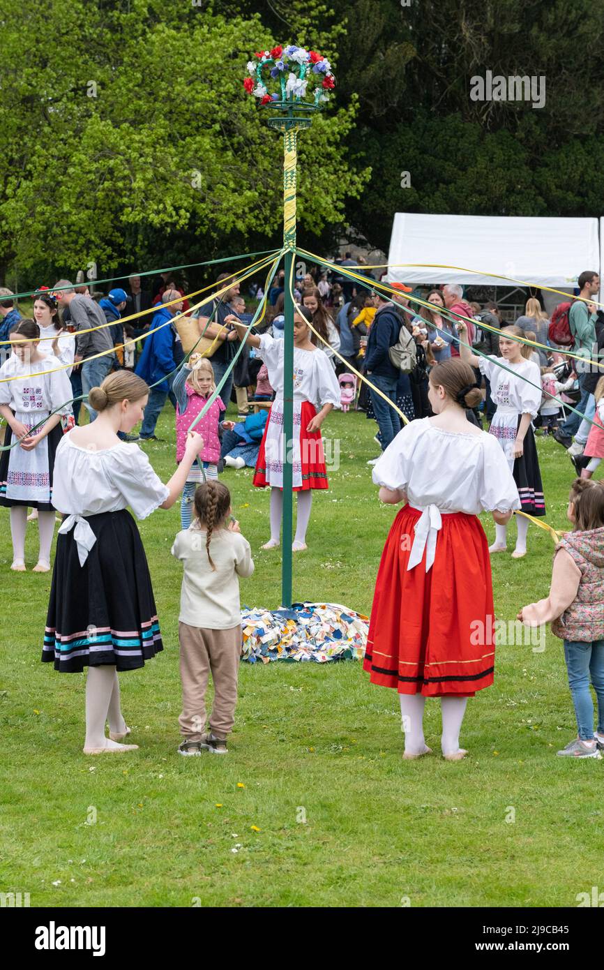 I bambini ballano intorno al Maypole sul verde del villaggio alla fiera di maggio dei Priori di Hurstbourne il 2nd 2022 maggio, Hampshire, Inghilterra Foto Stock