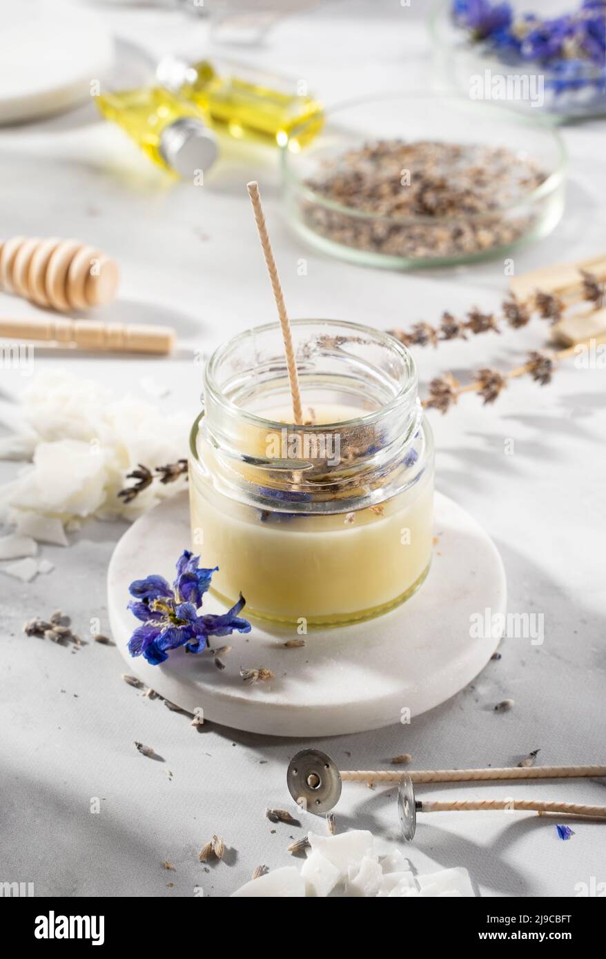 Set di strumenti per candele naturali eco-friendly di cera di soia, stoppino, profumo, olio essenziale su un tavolo di marmo. Processo di fabbricazione. Fai da te alla moda. Hobby artigianale, Foto Stock