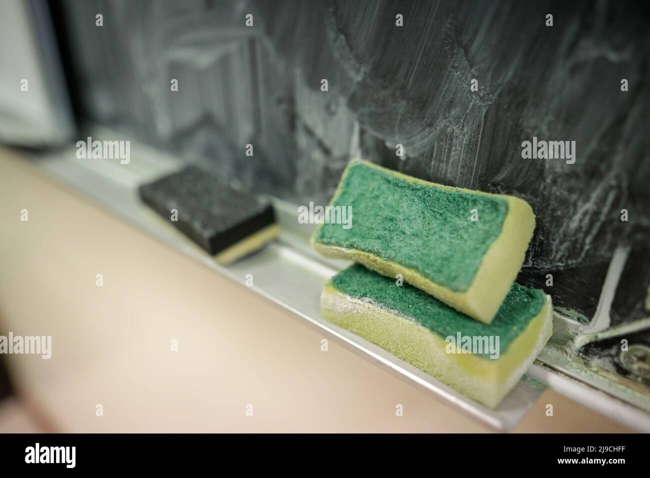 Profondità di campo poco profonda (fuoco selettivo) dettagli con una spugna utilizzata per la pulizia della lavagna da gesso in classe di una scuola primaria. Foto Stock