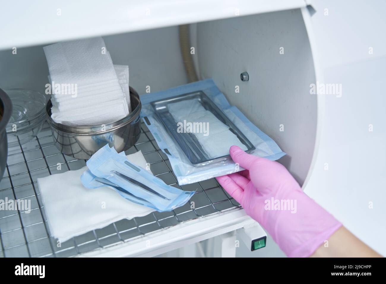 Operatore medico che prende gli strumenti dopo la sterilizzazione Foto Stock