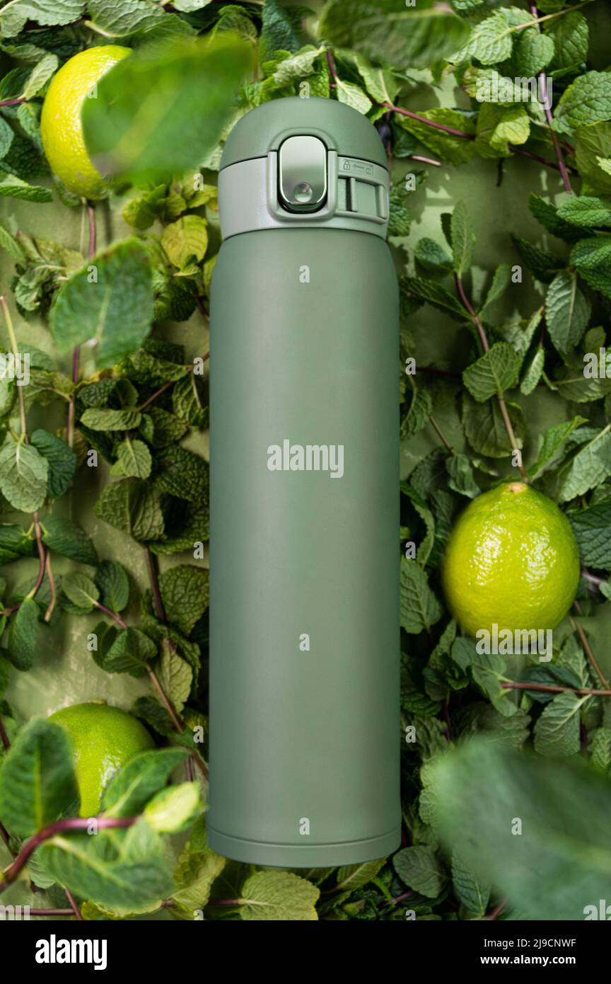 Thermos verdi con foglie di menta e limone. Thermos per immagazzinare le bevande  calde Foto stock - Alamy