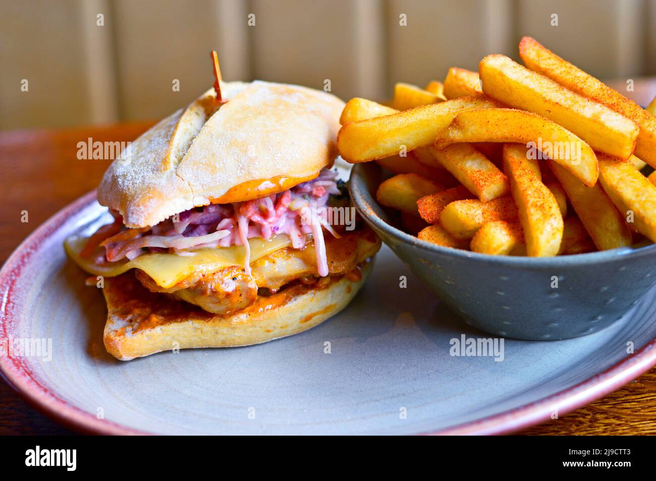 Hamburger con formaggio, carne alla griglia e patatine fritte (patatine fritte) poste sul tavolo del ristorante Foto Stock