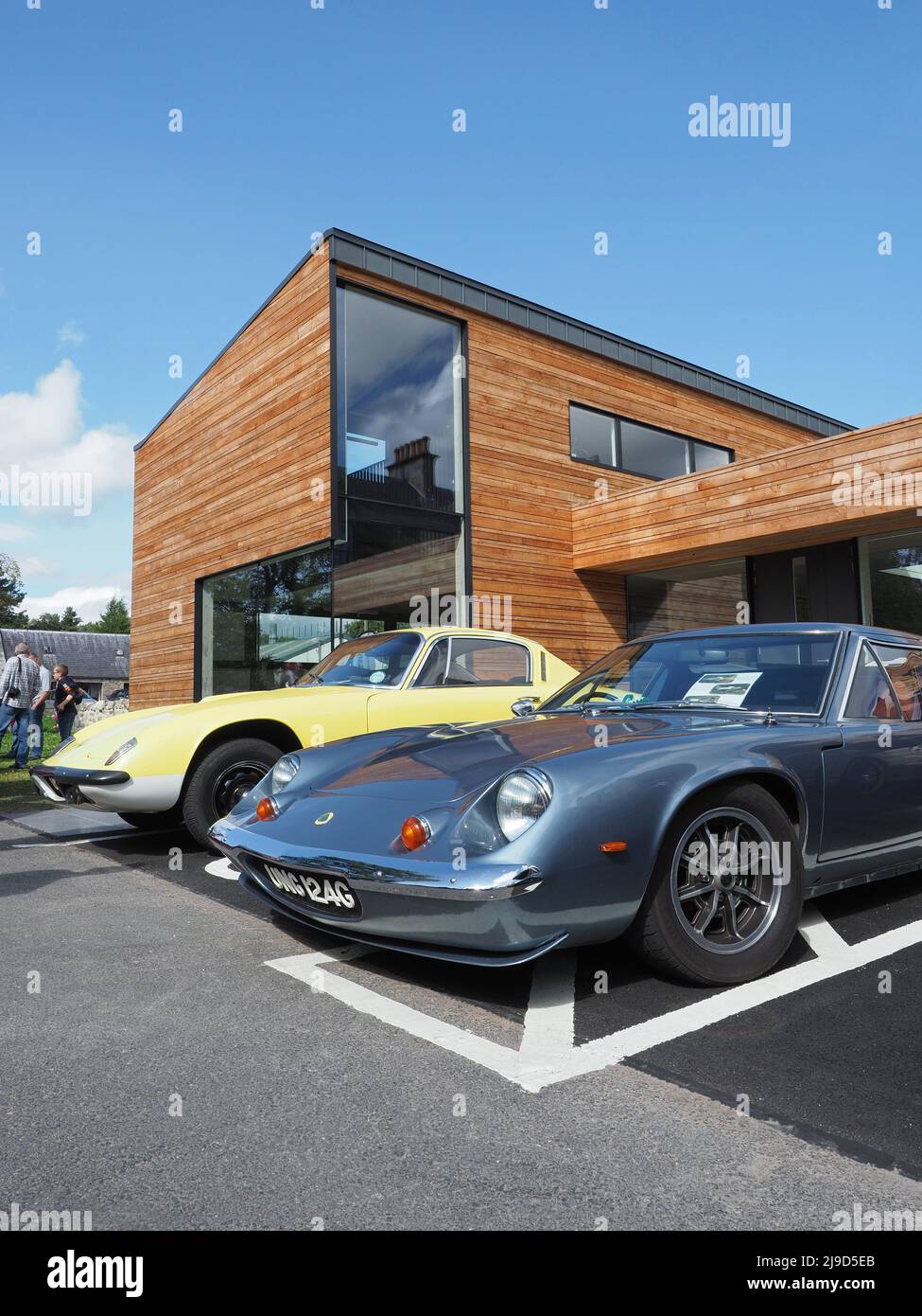 Lotus Europa S2, blu, costruito nel 1969, e Lotus Elan Plus 2 in giallo, costruito nel 1970. Dietro si trova la sede della Cairngorms National Park Authority. Foto Stock