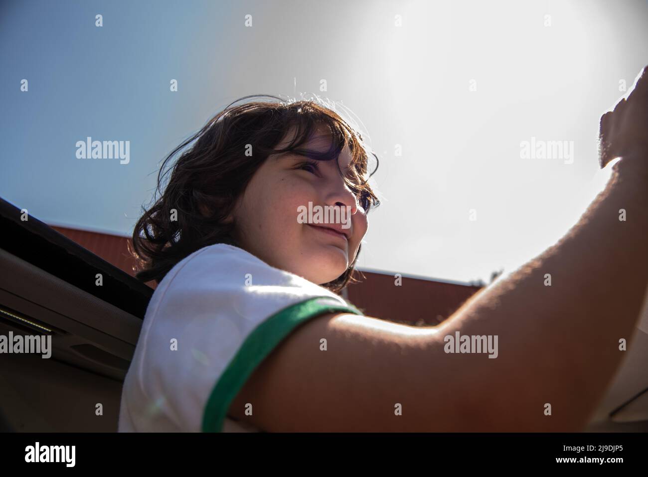 ritratto di una ragazza godere mentre fuori dal tetto di un cielo blu auto Foto Stock