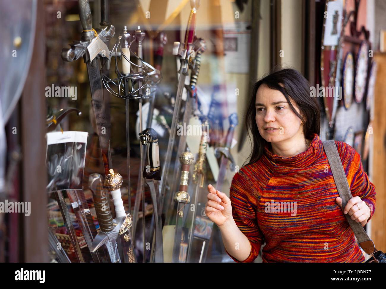 Donna turista che sceglie spade fatte a mano Foto Stock