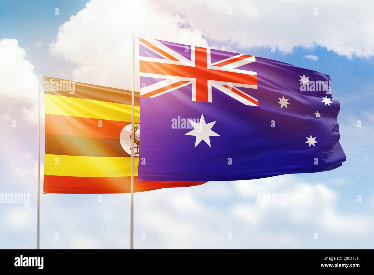 Cielo azzurro soleggiato e bandiere di australia e uganda Foto Stock