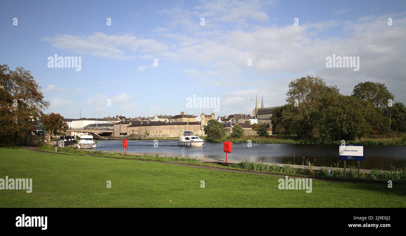 Il Castello di Enniskillen e la città di Enniskillen in autunno si affacciano sul fiume Erne con un'imbarcazione che naviga lungo il fiume Erne in Co Fermanagh. Foto Stock