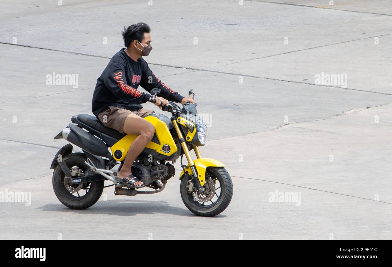 SAMUT PRAKAN, THAILANDIA, Apr 02 2022, un uomo con maschera di faccia corre una moto Foto Stock