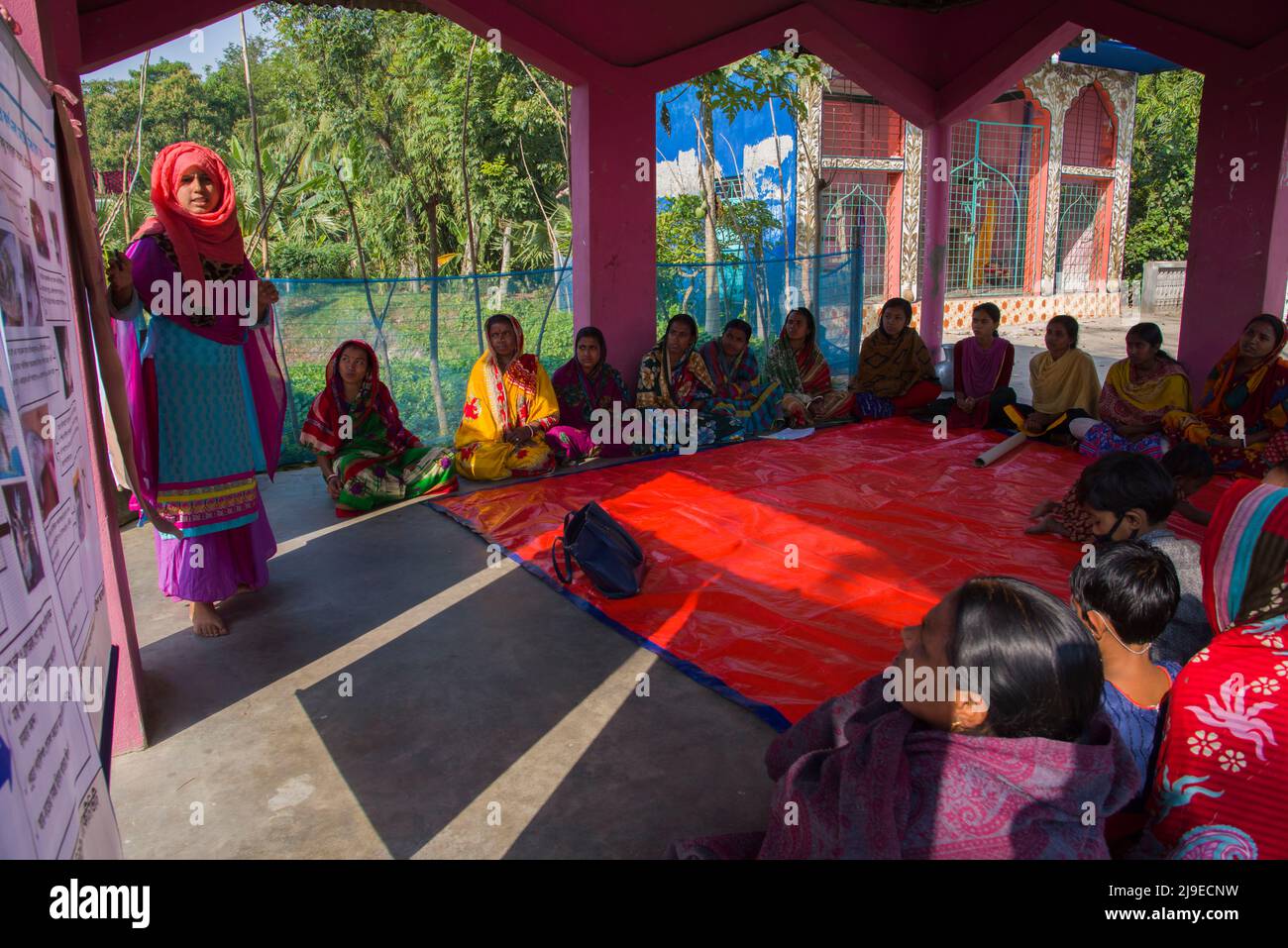I lavoratori delle ONG locali che conducono un incontro nel cortile per formare le donne rurali su nutrizione, igiene e genere nel distretto di Satkhira nel sud del Bangladesh Foto Stock