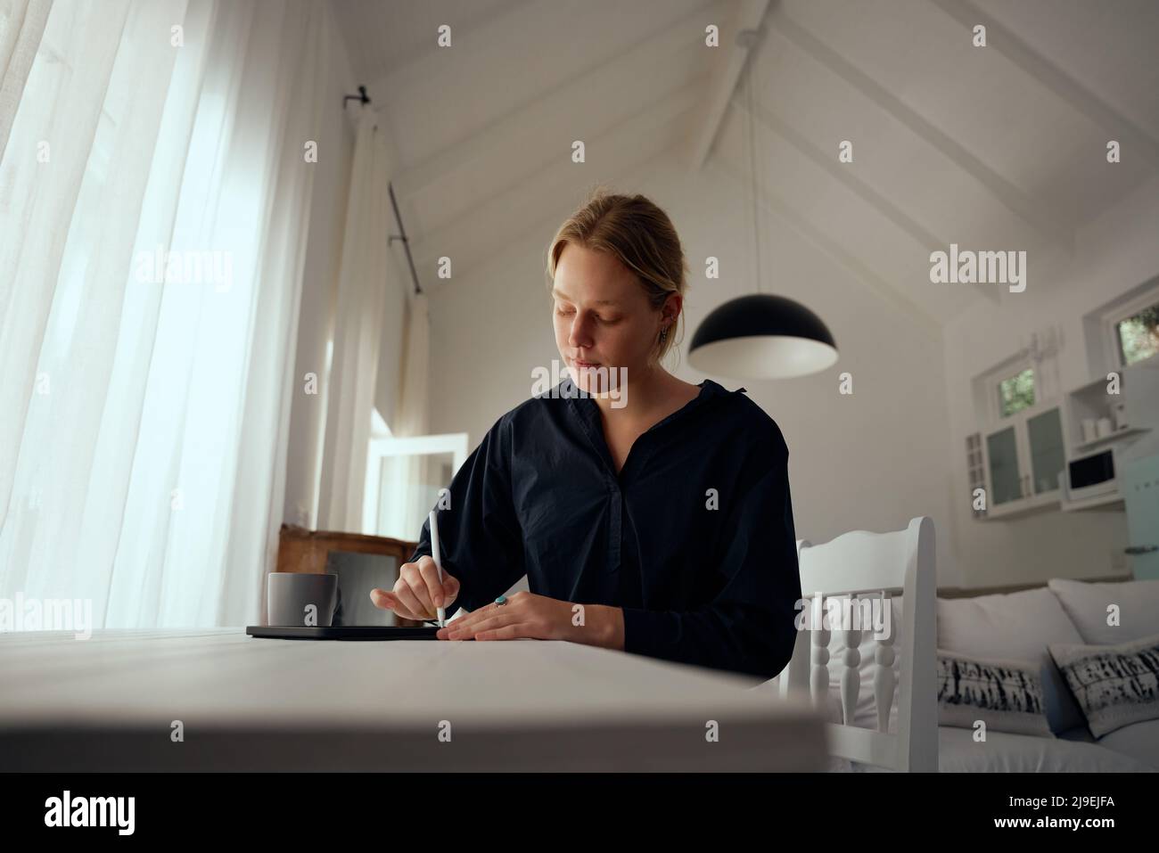 Fashion designer caucasica femminile che lavora da casa progettando arte su tablet digitale Foto Stock