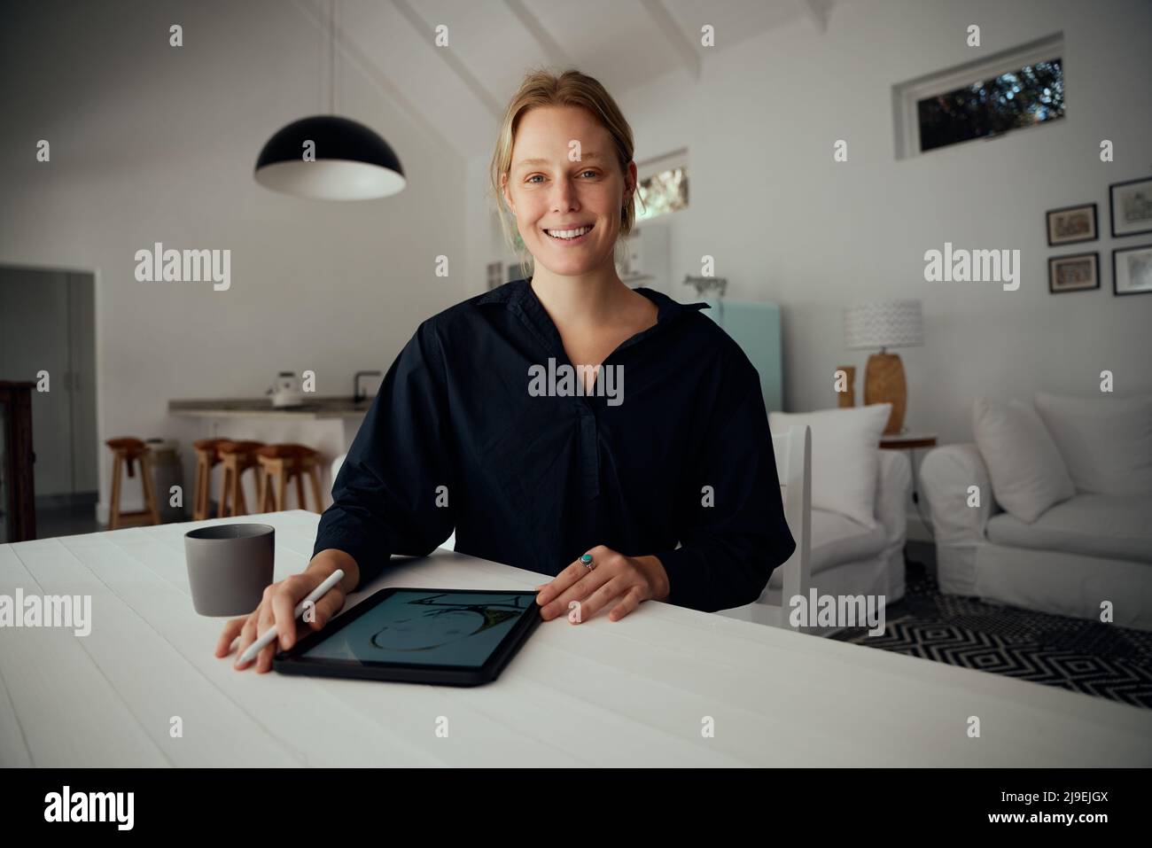 Fashion designer caucasica femminile che lavora da casa progettando arte su tablet digitale Foto Stock