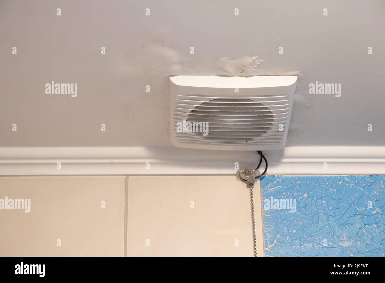 cappa elettrica sul soffitto nel bagno dell'appartamento, foro di ventilazione nel bagno sul soffitto Foto Stock