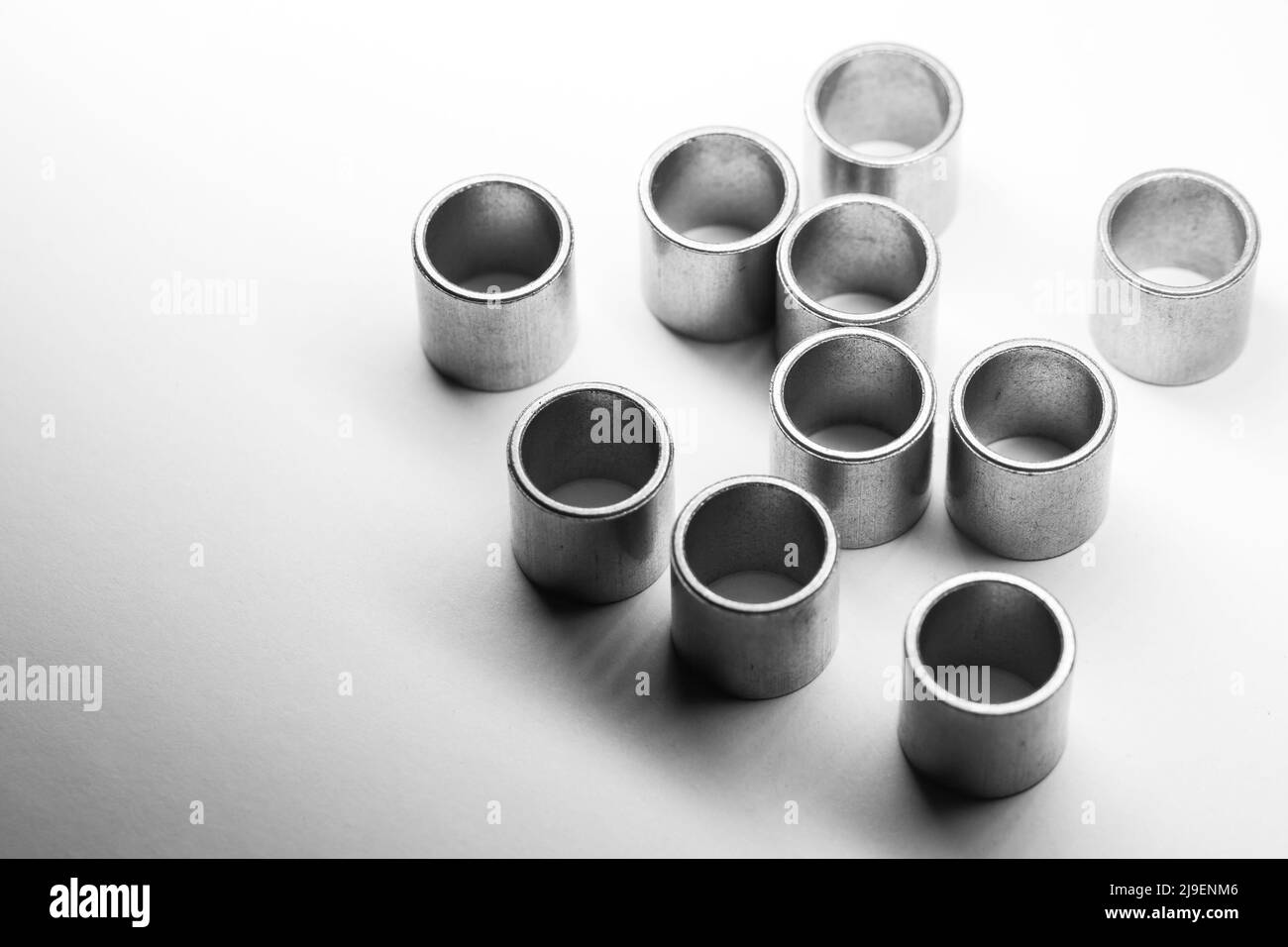 Dieci cuscinetti a manicotto si posizionano su uno sfondo bianco, foto primo piano con soft focus selettivo Foto Stock