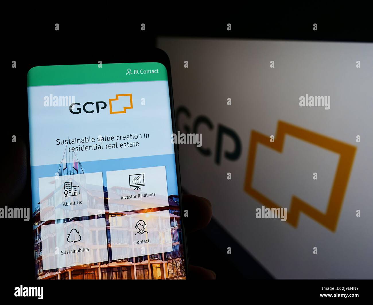 Persona che tiene smartphone con pagina web della società immobiliare Grand City Properties S.A. sullo schermo con logo. Concentrarsi sul centro del display del telefono. Foto Stock
