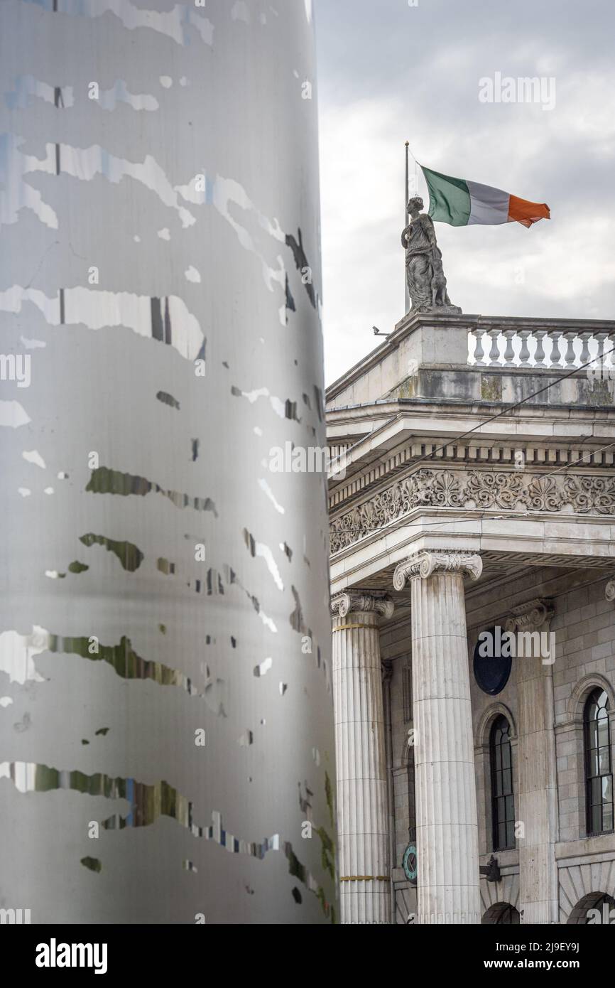 Millennium spire di Dublino su o'Connell Street con la bandiera irlandese che vola sopra il GPO Foto Stock